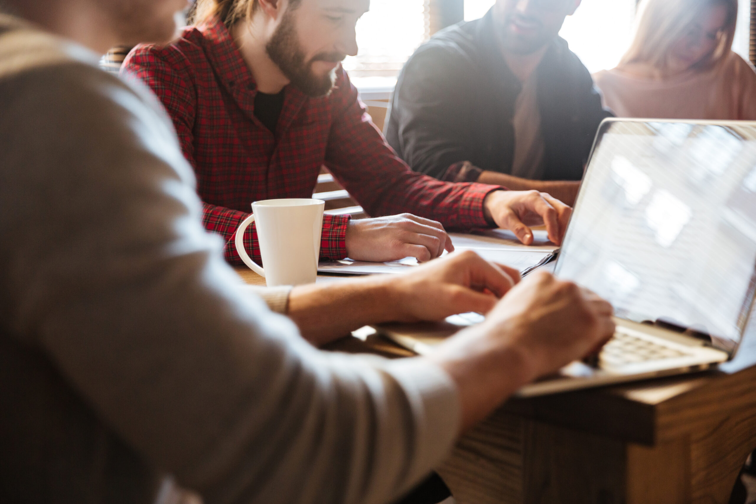 Cropped photo of young concentrated colleagues sitting in office and coworking.